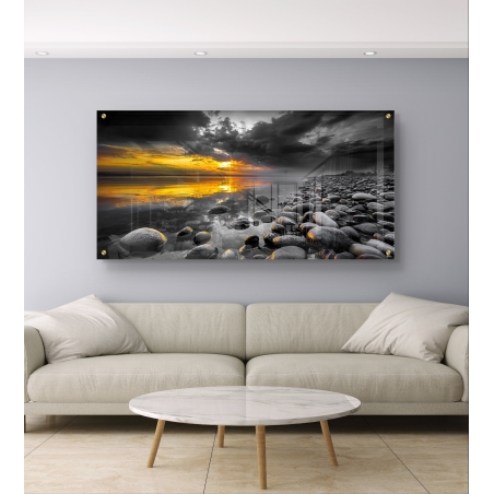 תמונת זכוכית לרוחב עם חוף סלעי בשחור-לבן ושקיעה מוזהבת – אור מול חושך