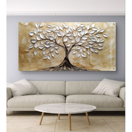 תמונת זכוכית רחבה עם עיצוב של עץ בעל עלים לבנים מבריקים על רקע בגווני בז’, תלויה מעל שולחן אוכל מודרני בחדר מואר עם רצפת שיש.