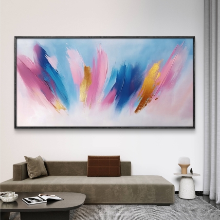תמונת קנבס לרוחב עם משיחות צבע בגווני ורוד, כחול, תכלת וזהב על רקע בהיר, בסגנון מופשט עכשווי – תלויה מעל ספה מודרנית בסלון.