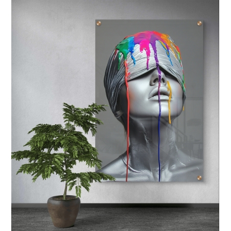 תמונת זכוכית של דמות נשית כסופה עם עיניים מכוסות, כאשר צבעים עזים נוזלים על פניה בסגנון מודרני ונועז, תלויה על קיר בסלון מעוצב.