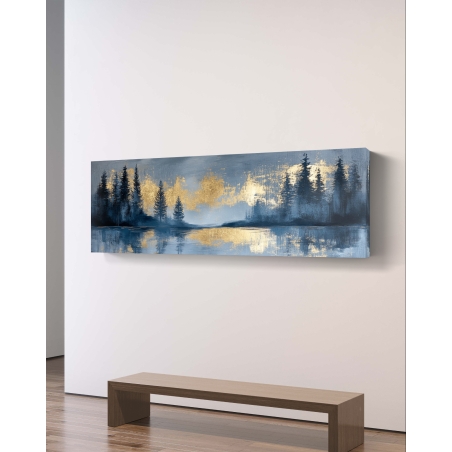 תמונת קנבס פנורמית עם נוף יער בגווני כחול וזהב, עצים מחודדים והשקפה במים, תלויה מעל ספה מודרנית בגוון כחול כהה.