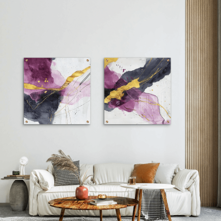 זוג תמונות זכוכית מרובעות תלויות מעל ספה לבנה בחלל מעוצב, עם נגיעות של צבע סגול עמוק, זהב מטאלי ושחור מופשט בקווים אמנותיים מודרניים.