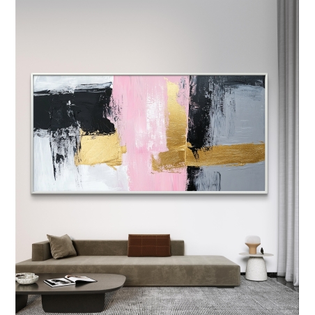 תמונת קנבס רחבה בסגנון אבסטרקט בצבעי ורוד, שחור, אפור וזהב תלויה מעל ספה מודרנית בחלל מעוצב.