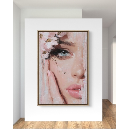 תמונת קנבס אורכית עם תקריב של פני אישה, הכוללת עין כחולה, שפתיים ורודות ופרחים ורודים, בעיצוב דמוי ציור מרוח – תלויה בסלון מודרני בעיצוב יוקרתי.