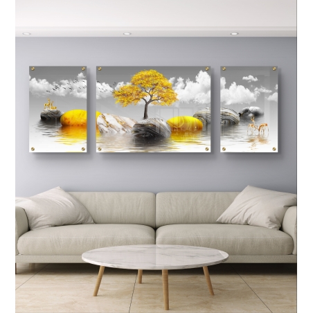 תמונה מחולקת מזכוכית – עץ זהב מרהיב על אבנים במים עם רקע עננים