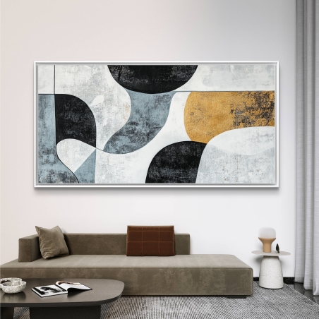 תמונת קנבס רוחבית בגווני שחור, אפור ולבן עם נגיעות זהב תלויה מעל ספה מודרנית בצבע בז', יוצרת אווירה אלגנטית ורגועה.