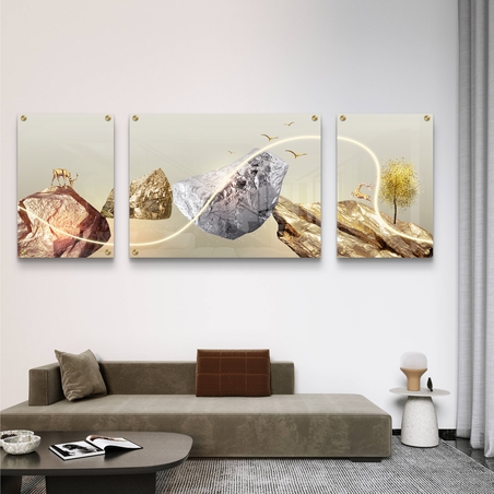 תמונה על זכוכית מחולקת לשלושה חלקים, עם הרים בגווני זהב וכסף, צבאים ועץ – מקולקציית תכשיט לבית