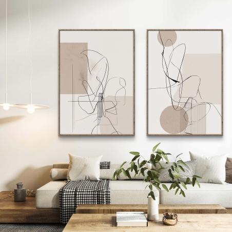 זוג תמונות קנבס בסגנון אבסטרקט מינימליסטי עם קווים שחורים דקים על רקע בגווני בז', תלויות מעל ספה בסלון מודרני בהיר.