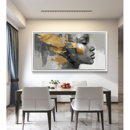 קנבס מודרני מעל ספה עם פנים נשיות אבסטרקטיות ומשיחות זהב יוקרתיות על רקע אפור