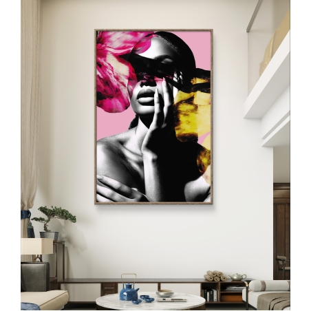 תמונת קנבס אנכית המציגה אישה בשחור-לבן כשעל פניה פרחים צבעוניים בגווני ורוד וכתום, תלויה על קיר לבן בסלון מעוצב בסגנון מודרני.