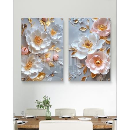 תמונה זוגית של זכוכית עם עיצוב פרחים תלת-ממדיים בגווני לבן וזהב, תלויה מעל שולחן אוכל בעיצוב מודרני.