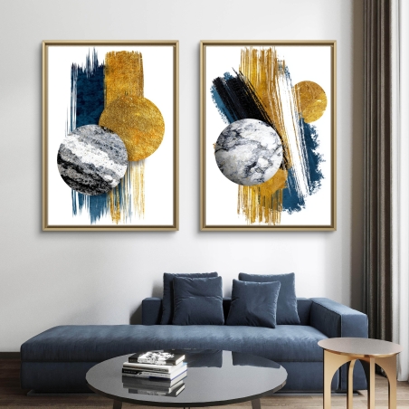 זוג תמונות קנבס מודרניות בעיצוב גאומטרי בגווני כחול, זהב ושיש, תלויות מעל ספה כחולה כהה בחלל סלון מעוצב.