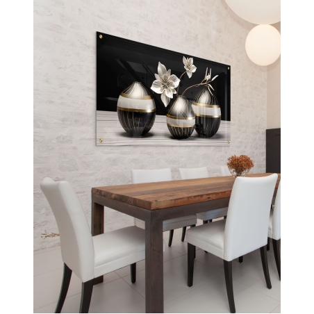 תמונת זכוכית לרוחב עם שלושה כדורי נוי שחורים-זהובים ופרחים לבנים עדינים – יצירה מודרנית יוקרתית לעיצוב פינת אוכל או סלון.