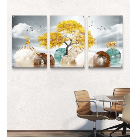 תמונה שלישיית זכוכית עם עץ זהוב במרכז ושני איילים מוזהבים משני הצדדים, על רקע עננים ומניפות גאומטריות, תלויה מעל ספה מודרנית כהה.