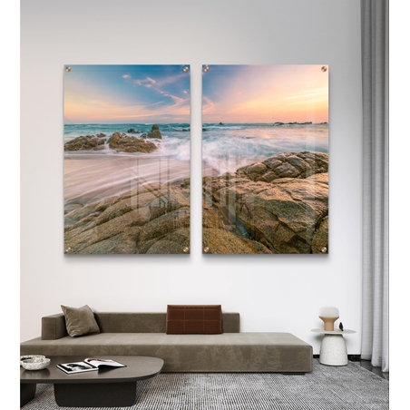זוג תמונות זכוכית עם חוף סלעי וגלים בתנועה רכה, שמיים פסטליים ועיצוב רגוע ואלגנטי לקיר הבית