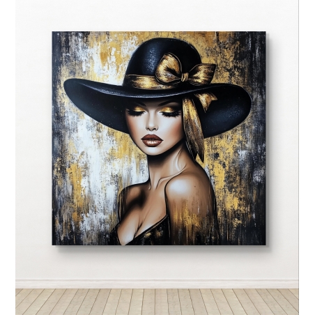 תמונת קנבס של אישה אלגנטית בכובע שחור עם סרט מוזהב, על רקע טקסטורה דומיננטית בגווני זהב, שחור ולבן, המוסיפה עומק ויוקרה לחלל מעוצב.