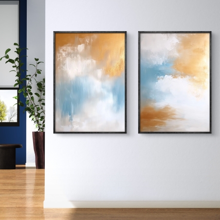 זוג תמונות קנבס מופשטות בגווני כחול, זהב ולבן, לעיצוב חללים מודרניים ומיוחדים, עם אווירה רכה ושלווה.