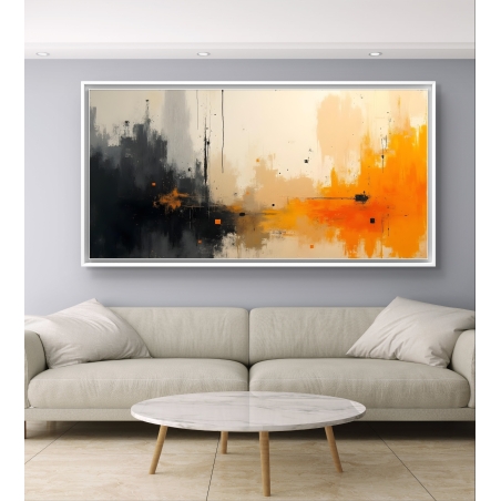 תמונת קנבס מופשטת בצבעים כתום, שחור וזהב תלויה מעל ספה אפורה מודרנית בסלון מעוצב.