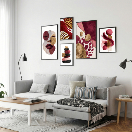 סט תמונות קנבס בגווני בורדו, ורוד וזהב עם פורטרט נשי ועיצוב אבסטרקטי מודרני תלוי מעל ספה בהירה בסלון מעוצב.