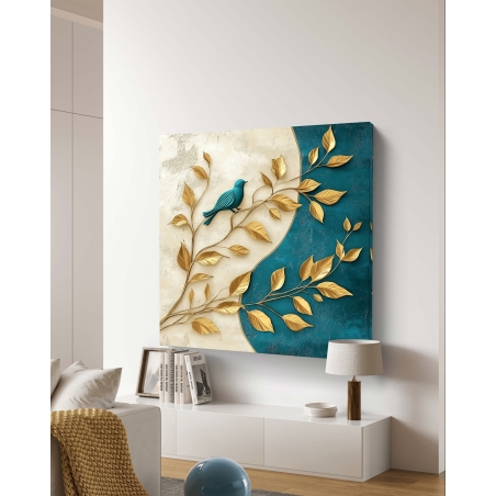 תמונת קנבס מרובעת עם ענף מוזהב, ציפור בגוון תכלת ורקע המחולק לצבעי קרם ותכלת עמוקה.