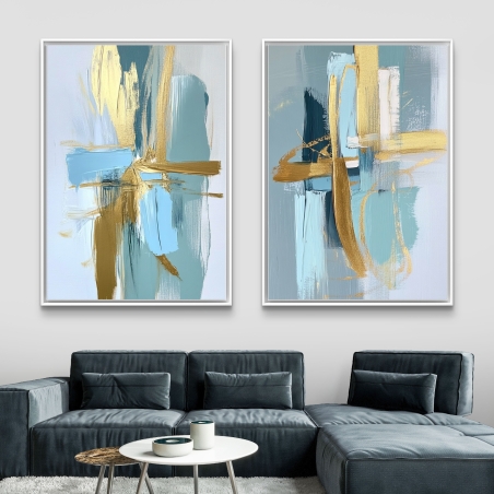 זוג תמונות קנבס מודרניות בגווני תכלת, אפור וזהב בעיצוב אבסטרקטי, תלויות מעל ספה בסלון מעוצב, מתוך הקולקציה של תכשיט לבית.