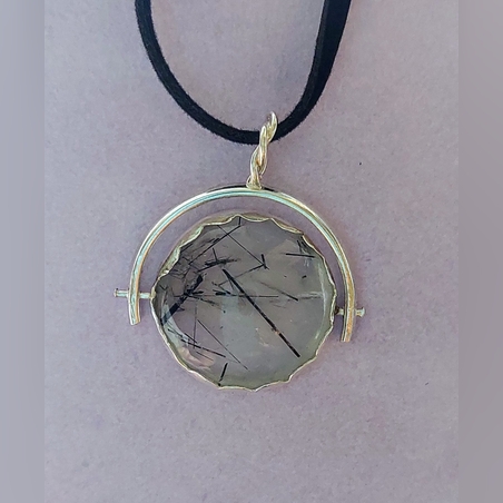 תליון עם אבן עגולה שמסתובבת על ציר