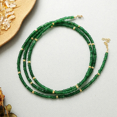 שרשרת ירוקה רב שכבתית מאבני אבנטורין עם חרוזים מוזהבים בעבודת יד על רקע בהיר.