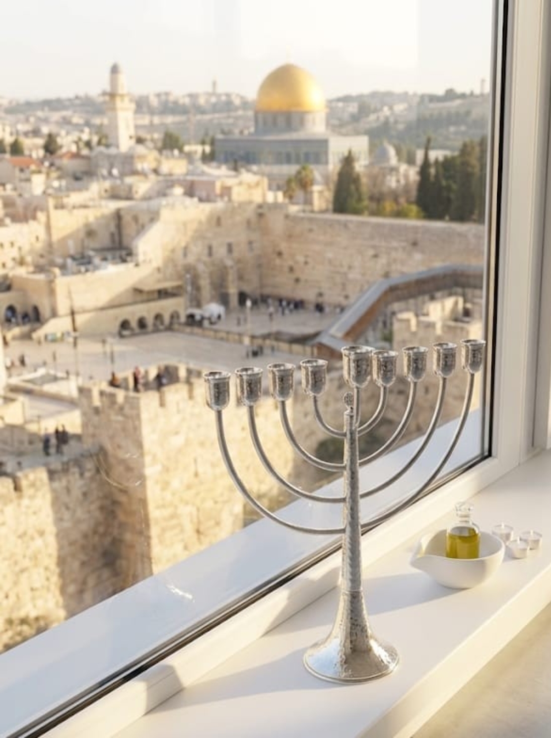 Traditional hammered Chanukah menorah made of 925 pure silver on a Jerusalem windowsill