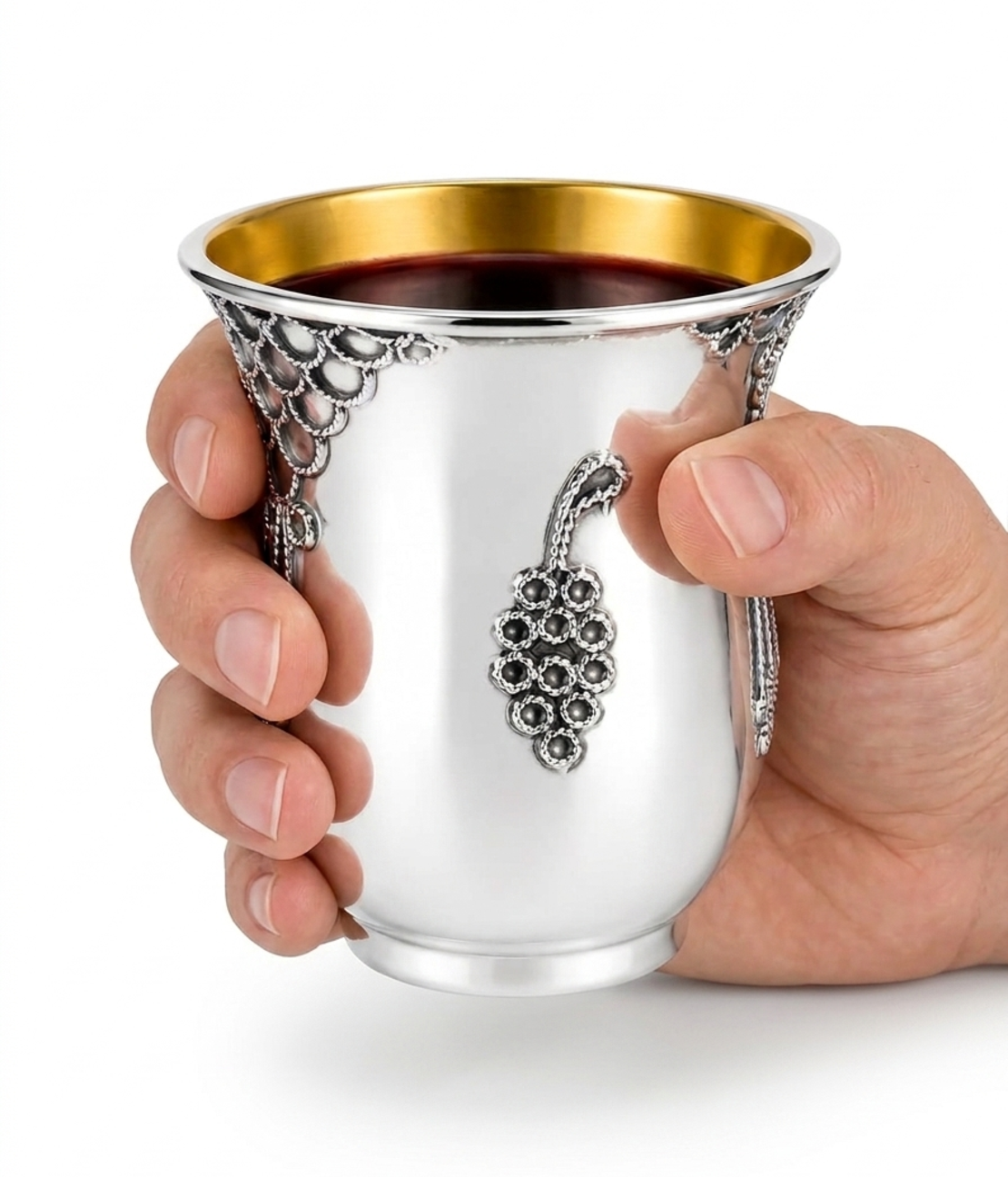 Hand holding a pure silver Kiddush cup, handmade, traditional filigree decoration