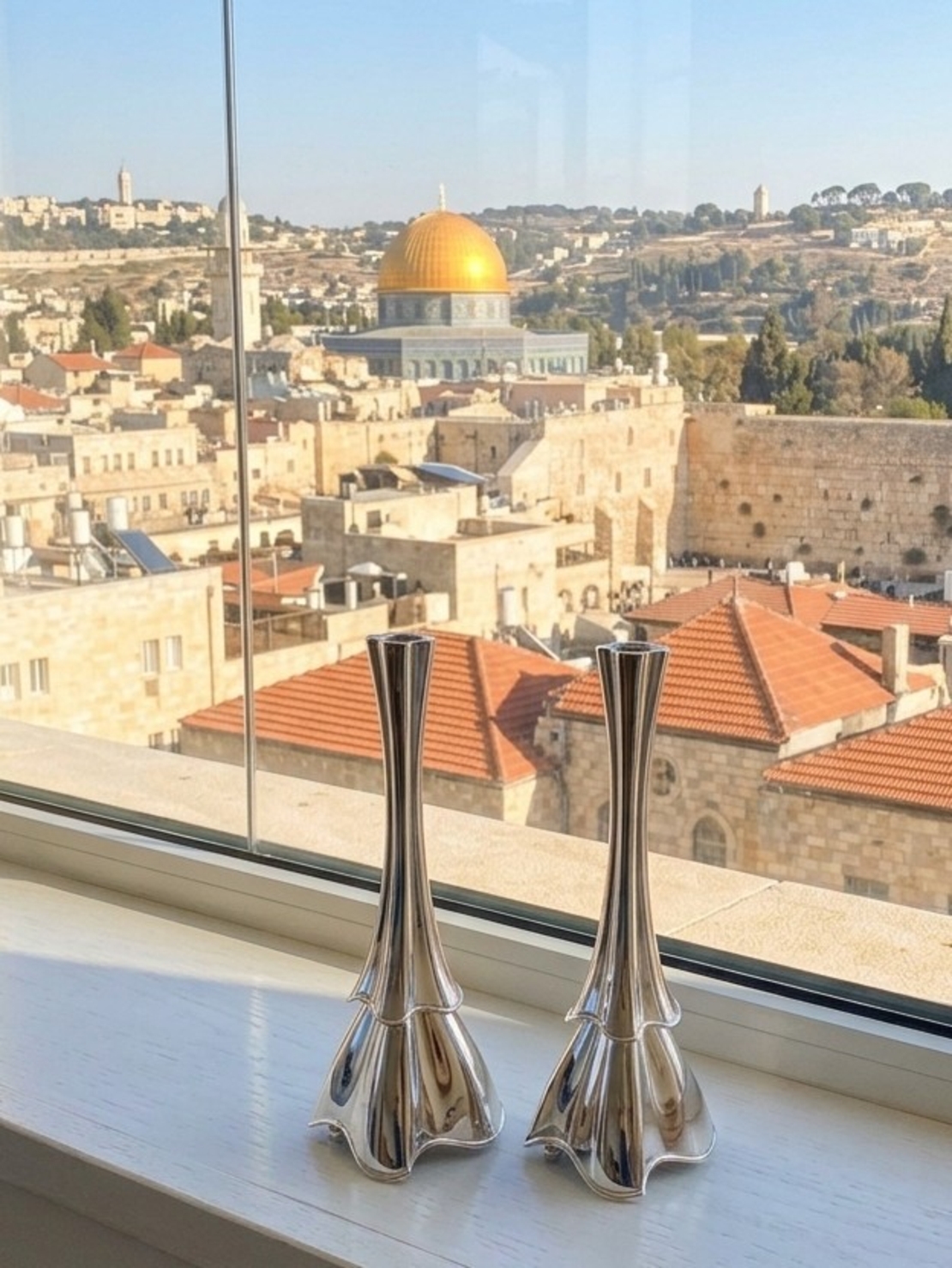 פמוטים מכסף טהור דגם איביזה – זוג פמוטי שבת בעיצוב פיסולי על אדן חלון ירושלמי