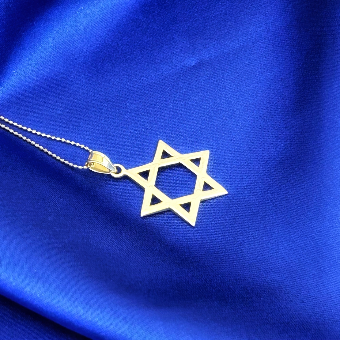 A large smooth 14k yellow gold Star of David pendant by designer Toni Roitman