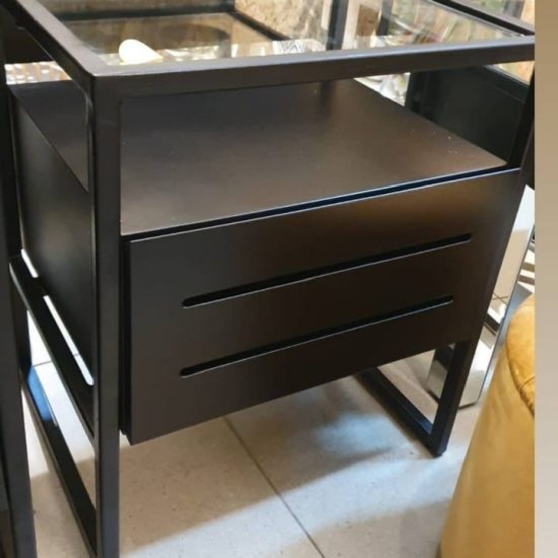 שידת מיטה בצבע שחור, מגירה מעץ, מסגרת ממתכת ומשטח עליון מזכוכית (50/40/50 ס