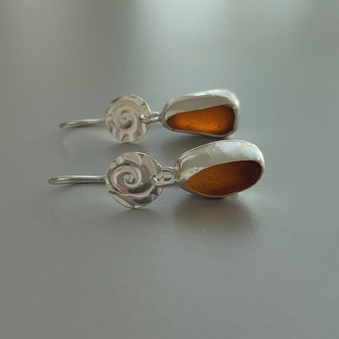 עגילי כסף עם זכוכיות ים חומות וספירלת כסף