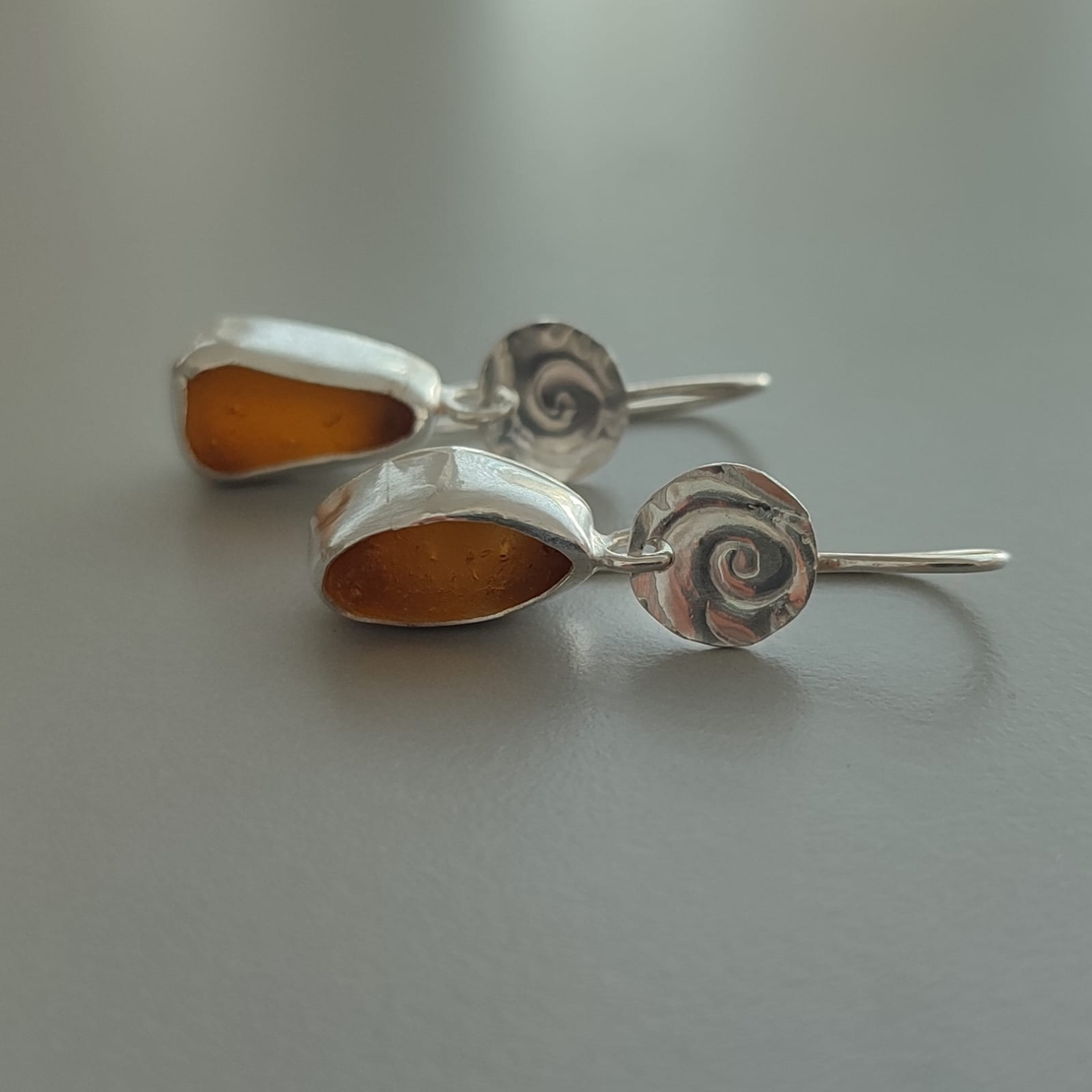 עגילי כסף עם זכוכיות ים חומות וספירלת כסף