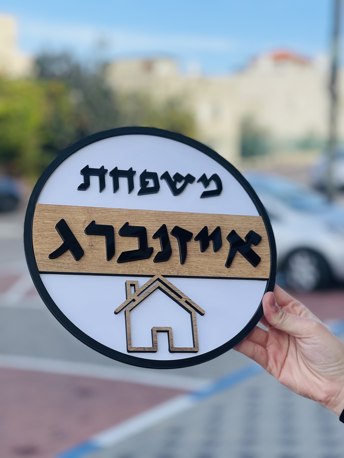שלט כניסה עגול לבית לבן בשילוב עץ ושחור