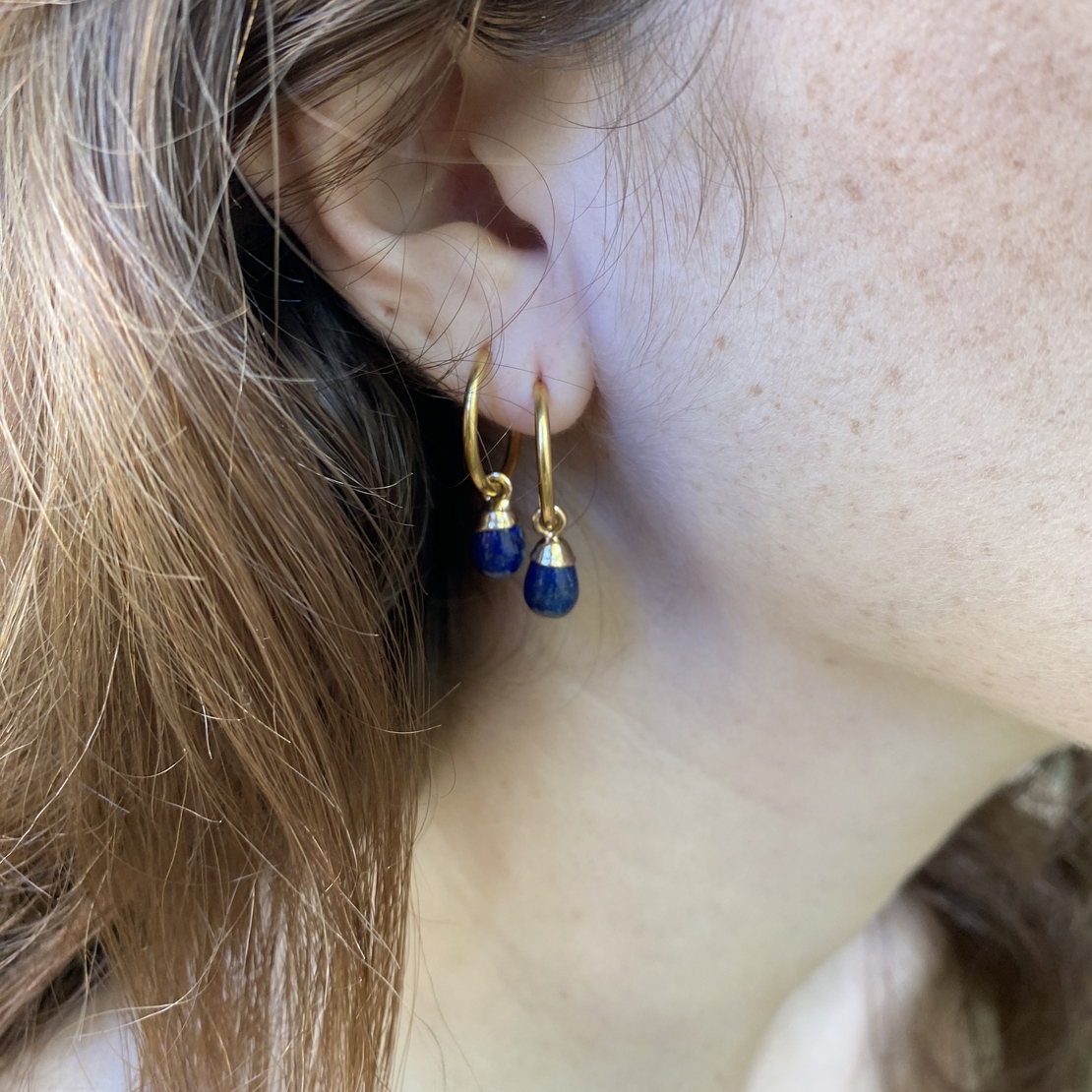 Thin hoop earring with a blue drop