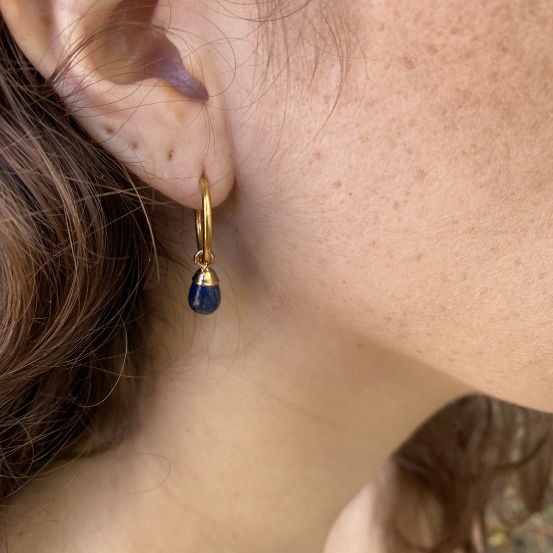 Thin hoop earring with a blue drop