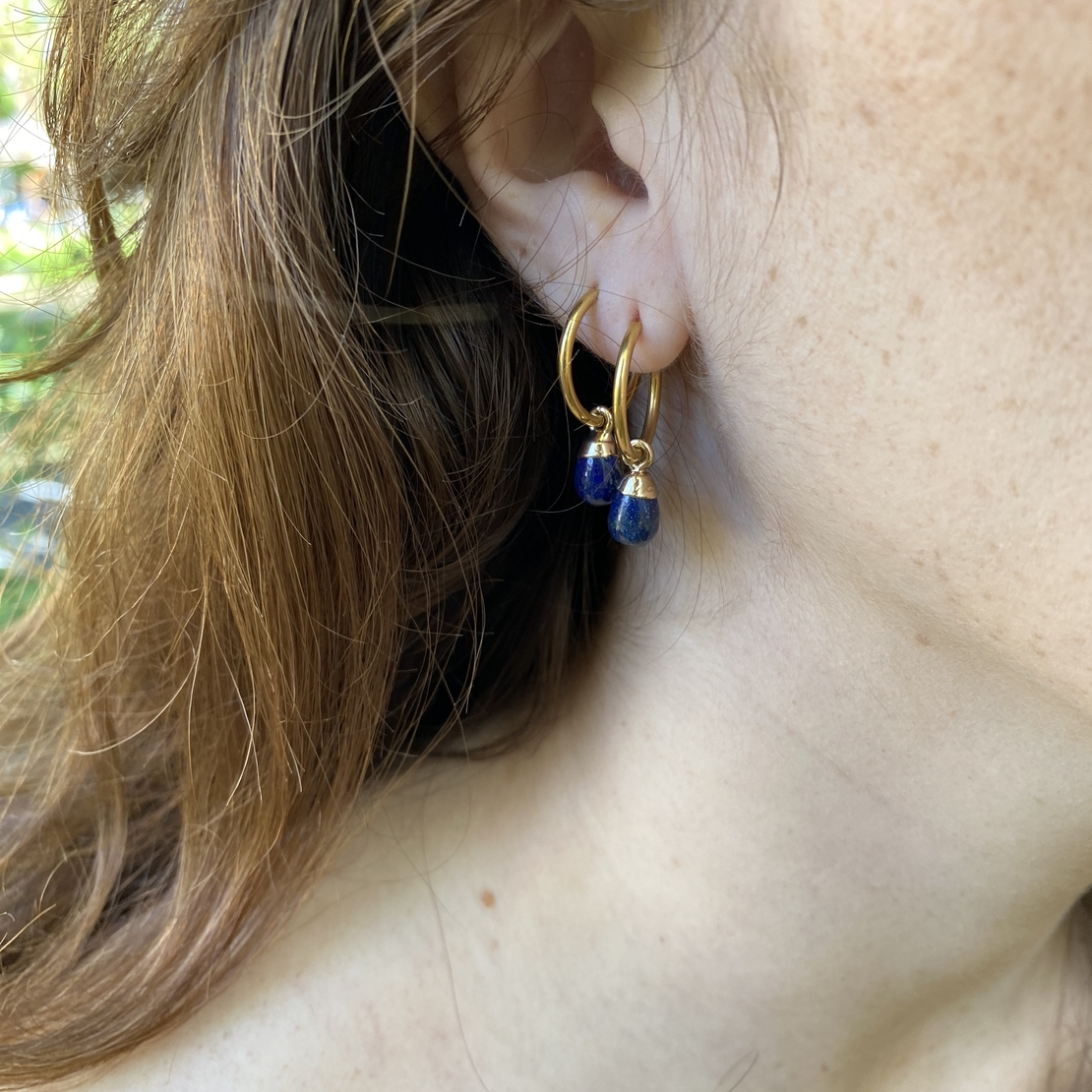 Thin hoop earring with a blue drop