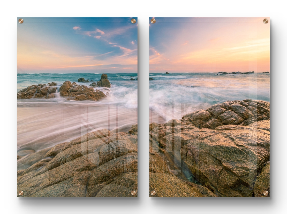 זוג תמונות זכוכית עם חוף סלעי וגלים בתנועה רכה, שמיים פסטליים ועיצוב רגוע ואלגנטי לקיר הבית