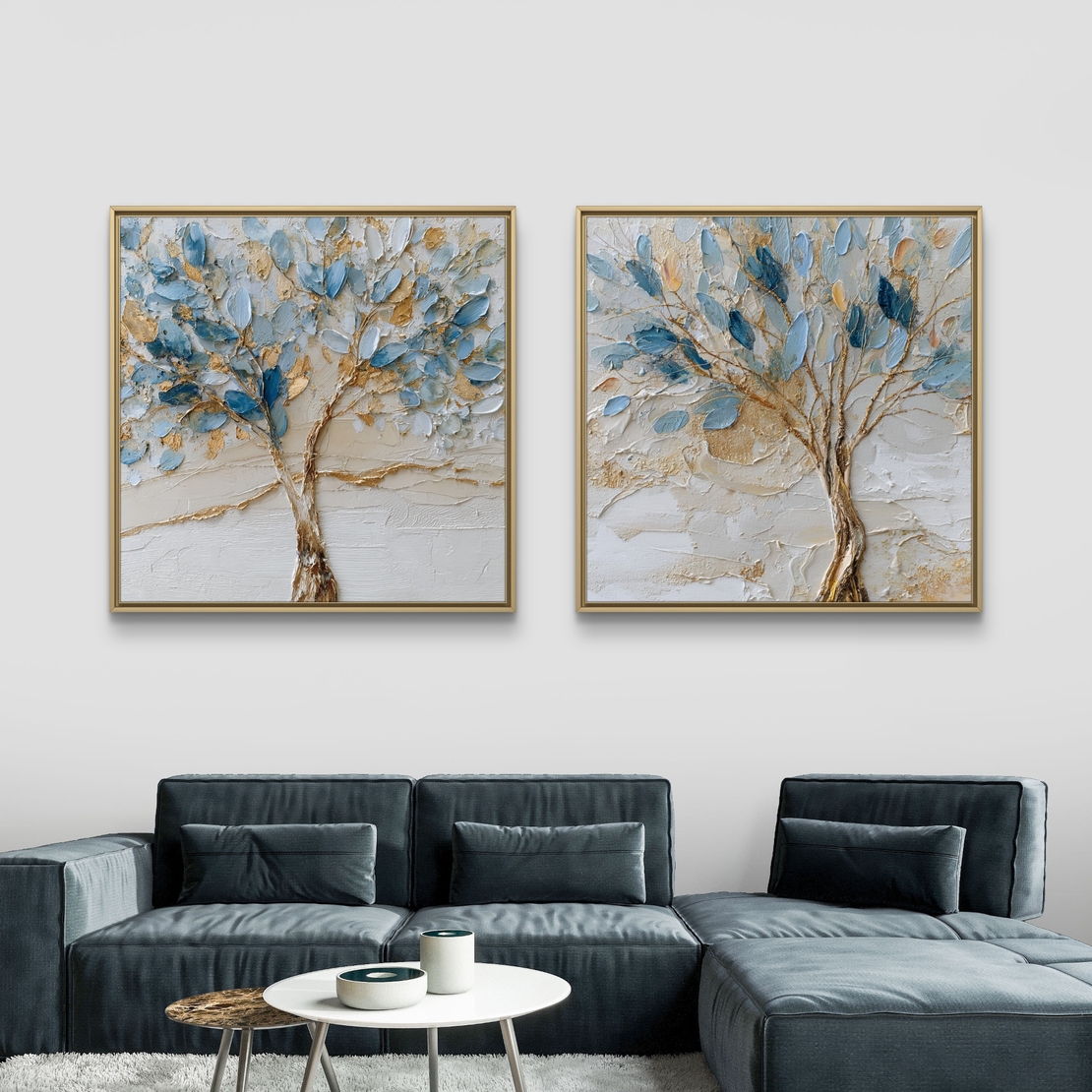 סט זוג תמונות קנבס מרובעות עם עצים אמנותיים בגווני כחול ותכלת ונגיעות זהב על רקע שמנתי, תלויות מעל ספה מודרנית.