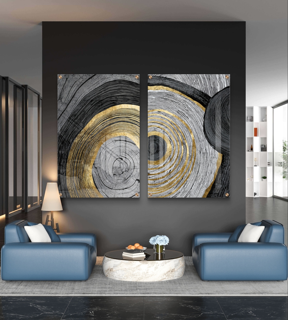 סט תמונות זכוכית זוג בעיצוב אבסטרקטי עם מעגלים קונצנטריים בגווני שחור, אפור ולבן עם נגיעות זהב מעל ספה מודרנית כחולה.