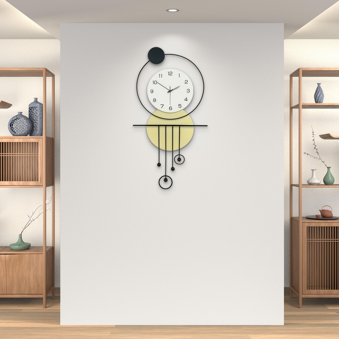 שעון קיר מעוצב בסגנון מודרני עם צורות גאומטריות, מסגרת עגולה, מטוטלות דקורטיביות וגימור אלגנטי בגווני שחור, לבן וזהב, תלוי על קיר בהיר.