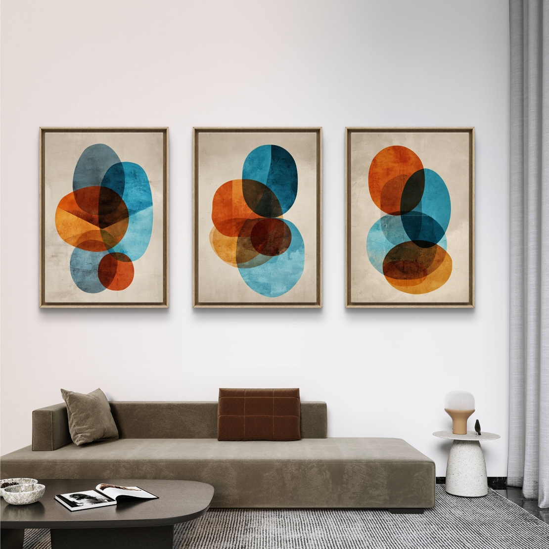 סט של שלוש תמונות קנבס אבסטרקטיות עם צורות עגולות בגווני כחול, כתום וחום על רקע בהיר, בעיצוב מודרני ואלגנטי לסלון.