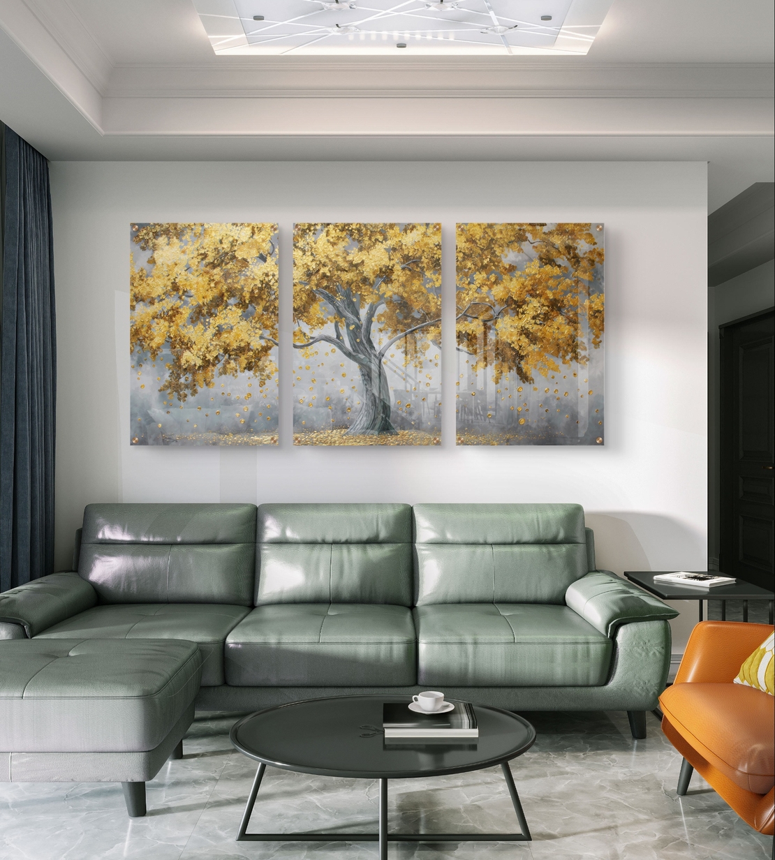 תמונת זכוכית שלישייה עם עץ זהוב ועלים מרחפים על רקע אפור בעיצוב מודרני