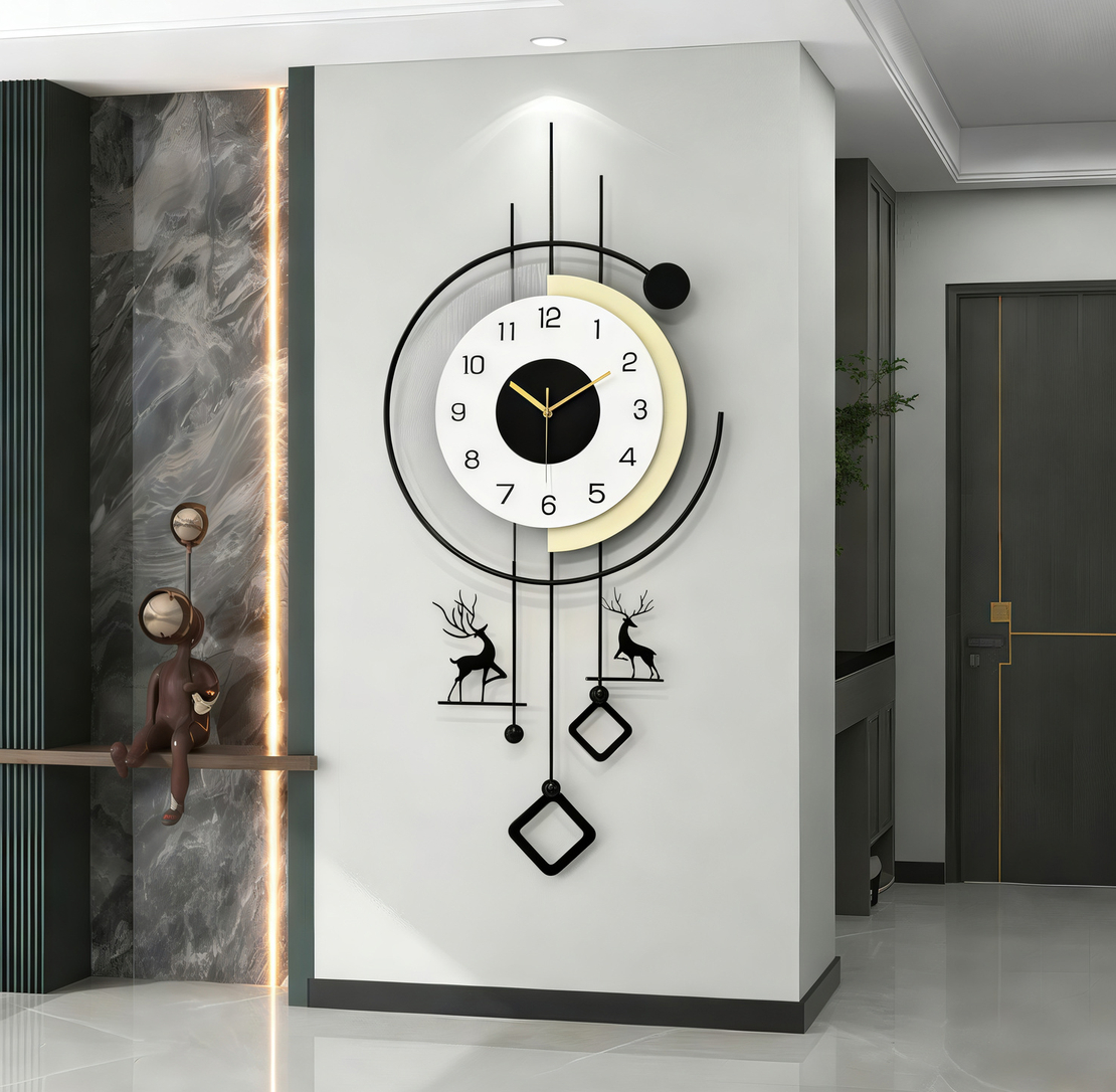 שעון קיר מעוצב בסגנון מודרני עם מסגרת עגולה, קווים גאומטריים, מטוטלות דקורטיביות ודמויות צבי בגווני שחור, לבן וזהב, תלוי על קיר בהיר בעיצוב יוקרתי.