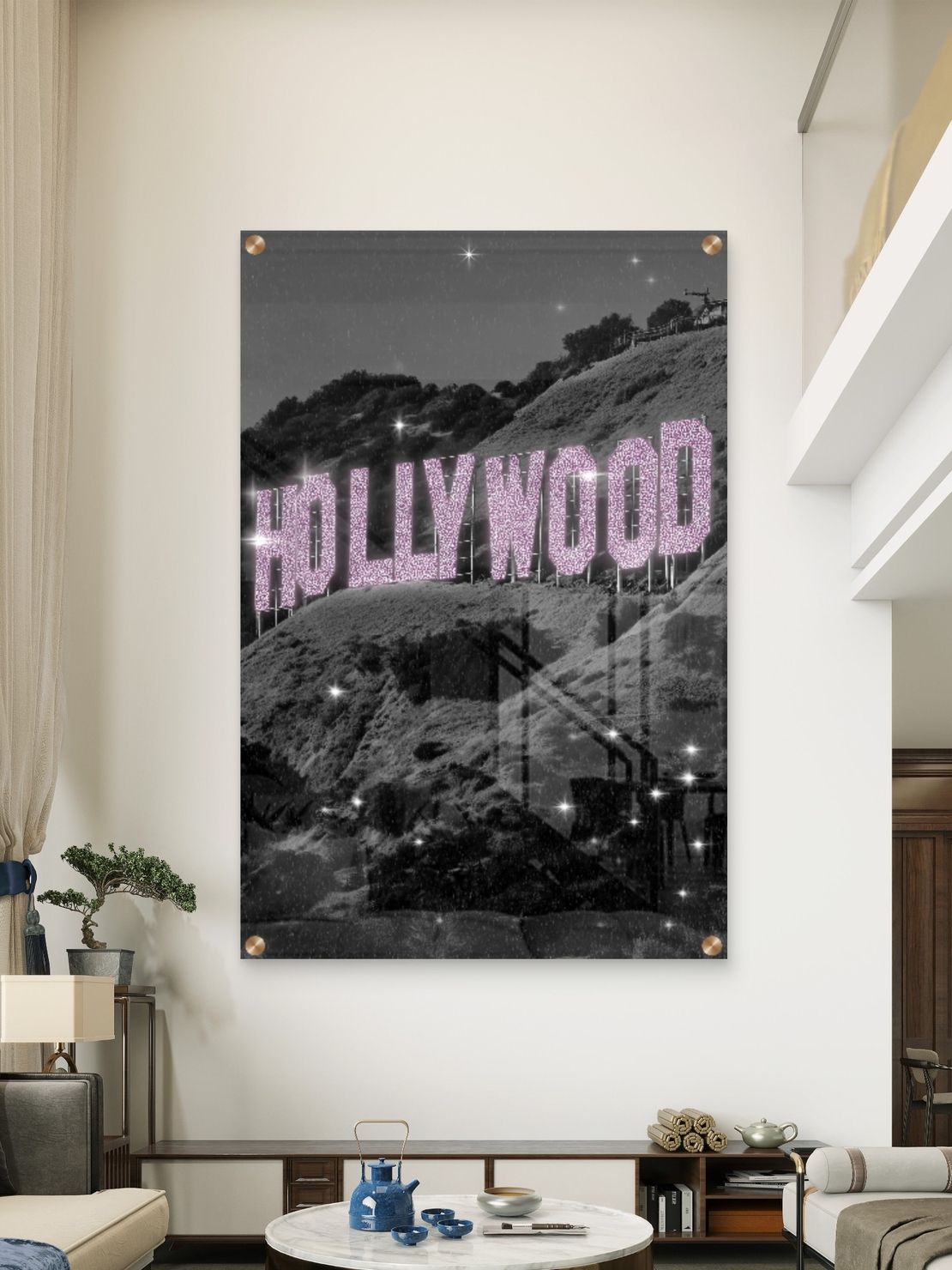 תמונת זכוכית של שלט HOLLYWOOD בגווני שחור־לבן עם אותיות ורודות מנצנצות, מתוך קולקציית NEXTGEN BY BAR של תכשיט לבית.