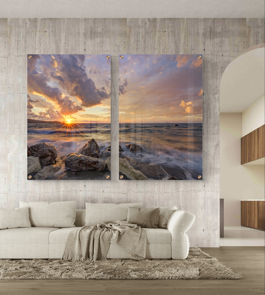 זוג תמונות זכוכית עם שקיעה מעל הים, סלעים וגלים בתנועה עדינה בעיצוב רגוע ואלגנטי לקיר הבית