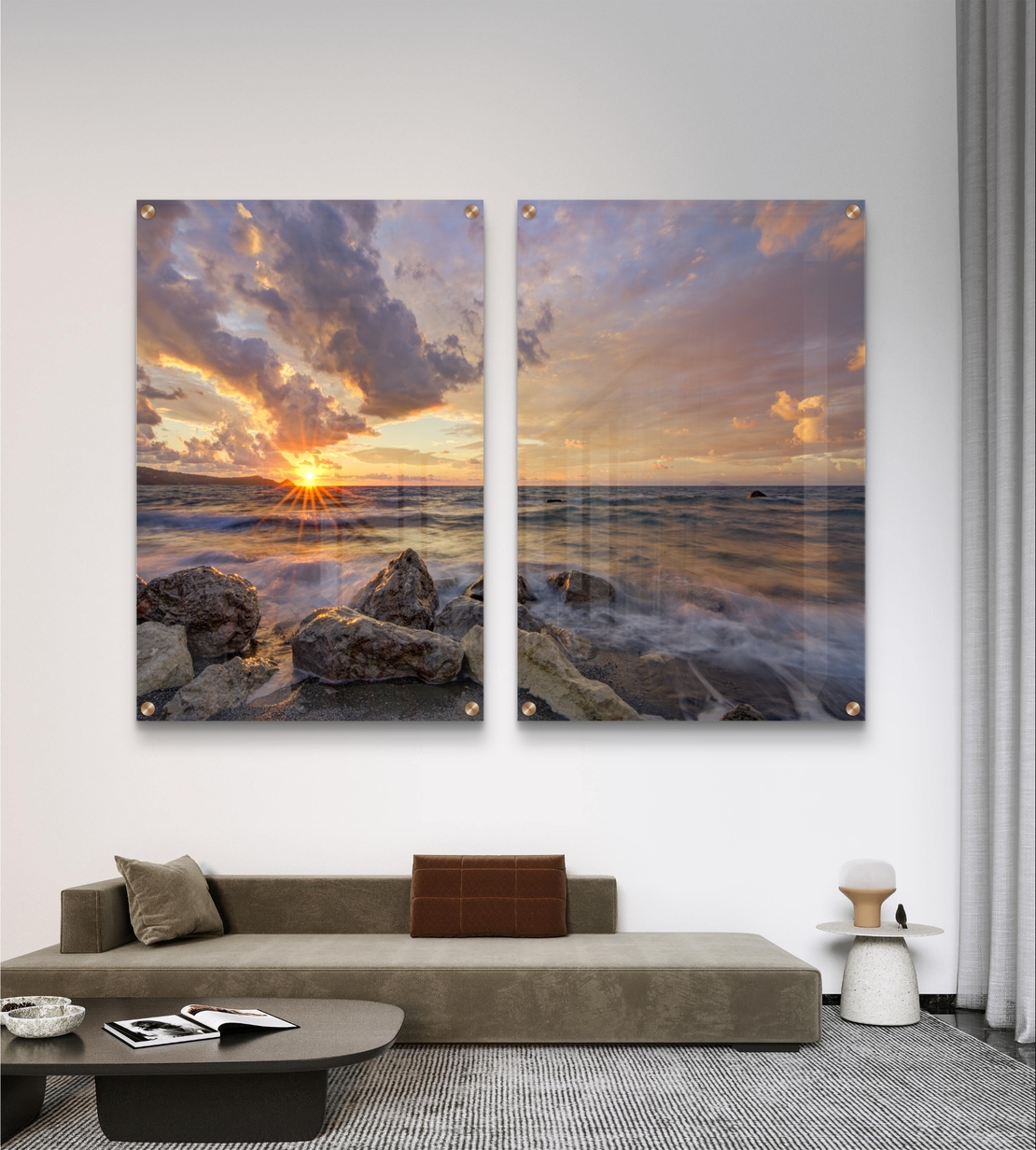 זוג תמונות זכוכית עם שקיעה מעל הים, סלעים וגלים בתנועה עדינה בעיצוב רגוע ואלגנטי לקיר הבית