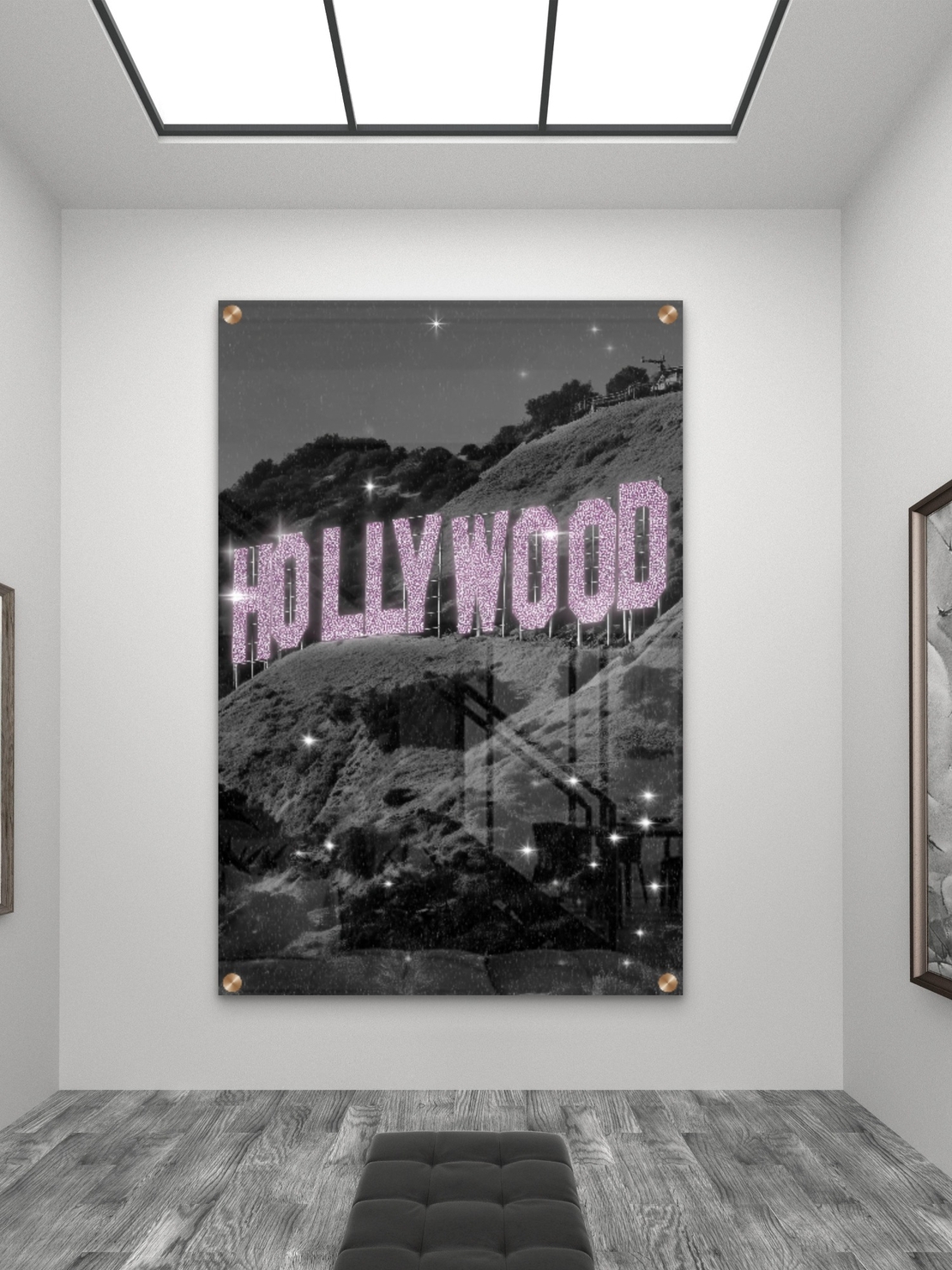 תמונת זכוכית של שלט HOLLYWOOD בגווני שחור־לבן עם אותיות ורודות מנצנצות, מתוך קולקציית NEXTGEN BY BAR של תכשיט לבית.
