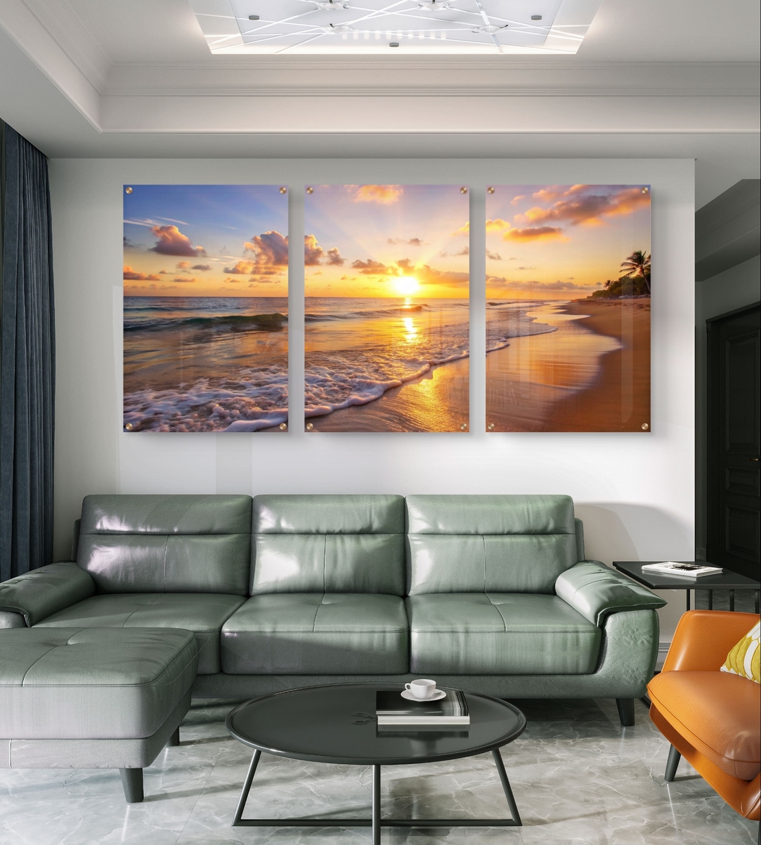 שלישיית תמונות זכוכית עם שקיעה זהובה על חוף הים, גלים עדינים וצבעים חמים בעיצוב רגוע ואלגנטי לסלון